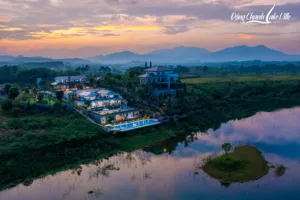 Toàn cảnh Đồng Chanh Lake Ville Hòa Bình nhìn từ flycam lúc hoàng hôn, hồ bơi sát mặt hồ, công trình nghỉ dưỡng do Archiindex thiết kế